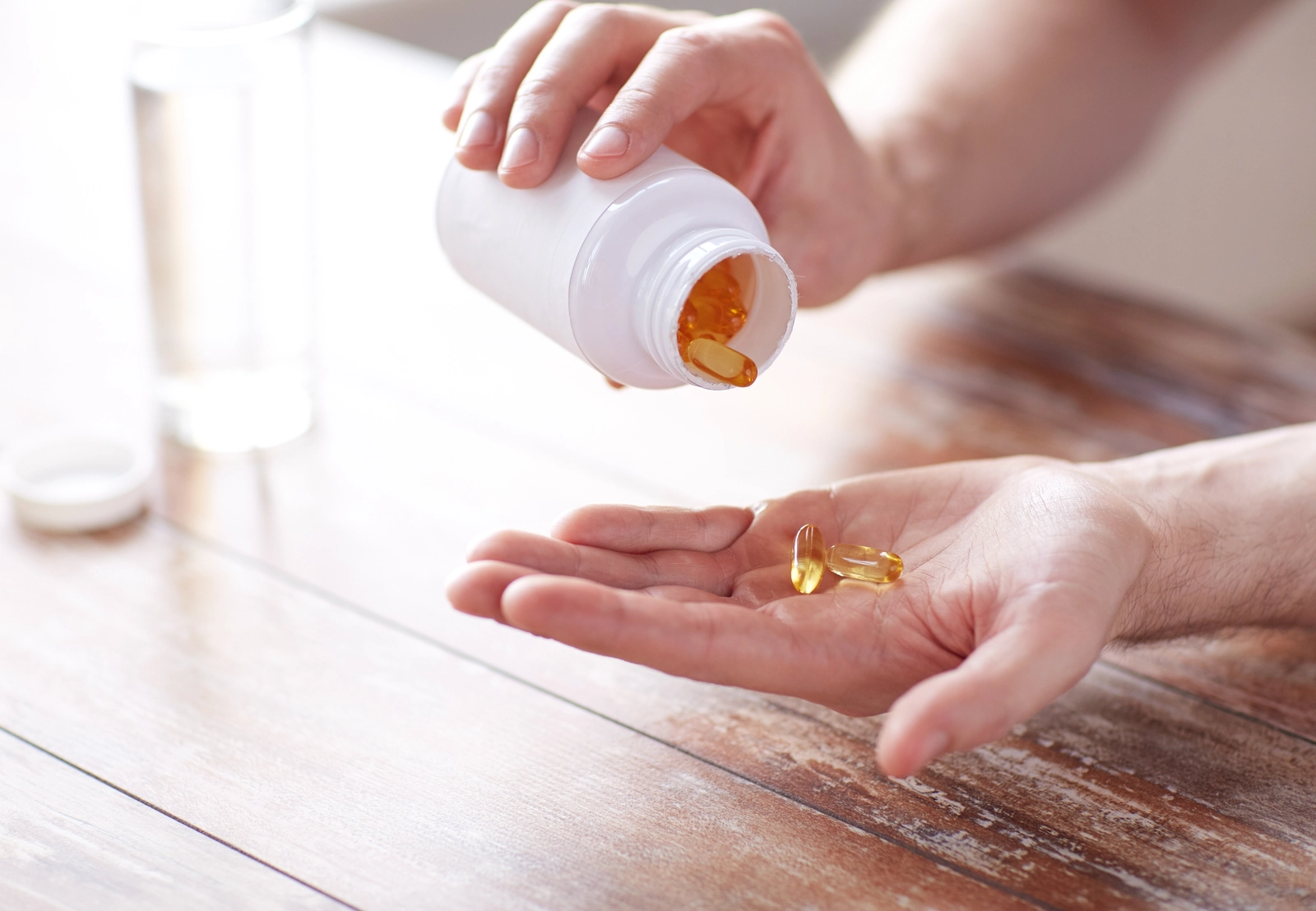 gabapentin can cause constipation; person pouring capsules into their hand from a bottle