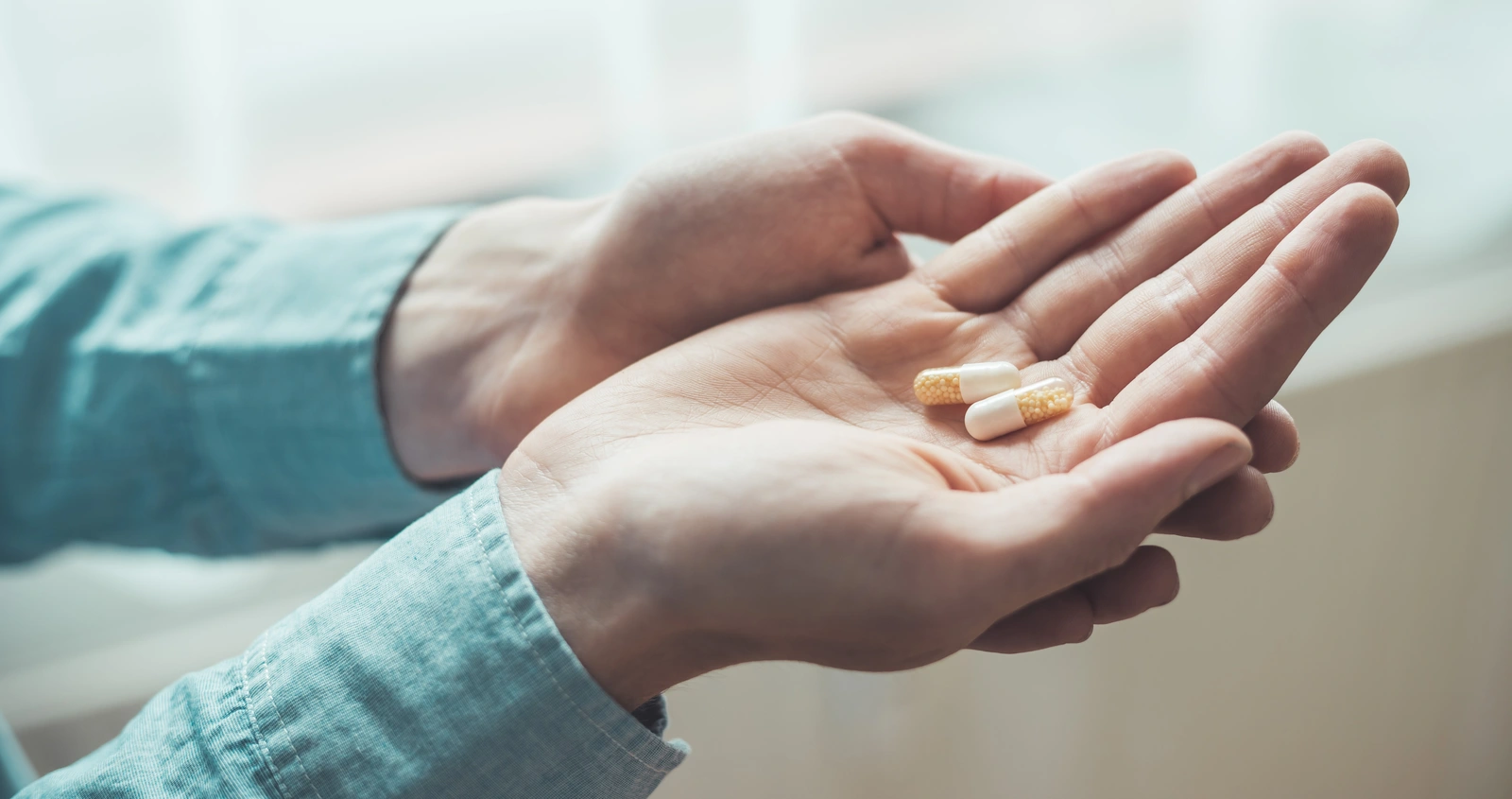 hands holding pills, ibuprofen with meloxicam