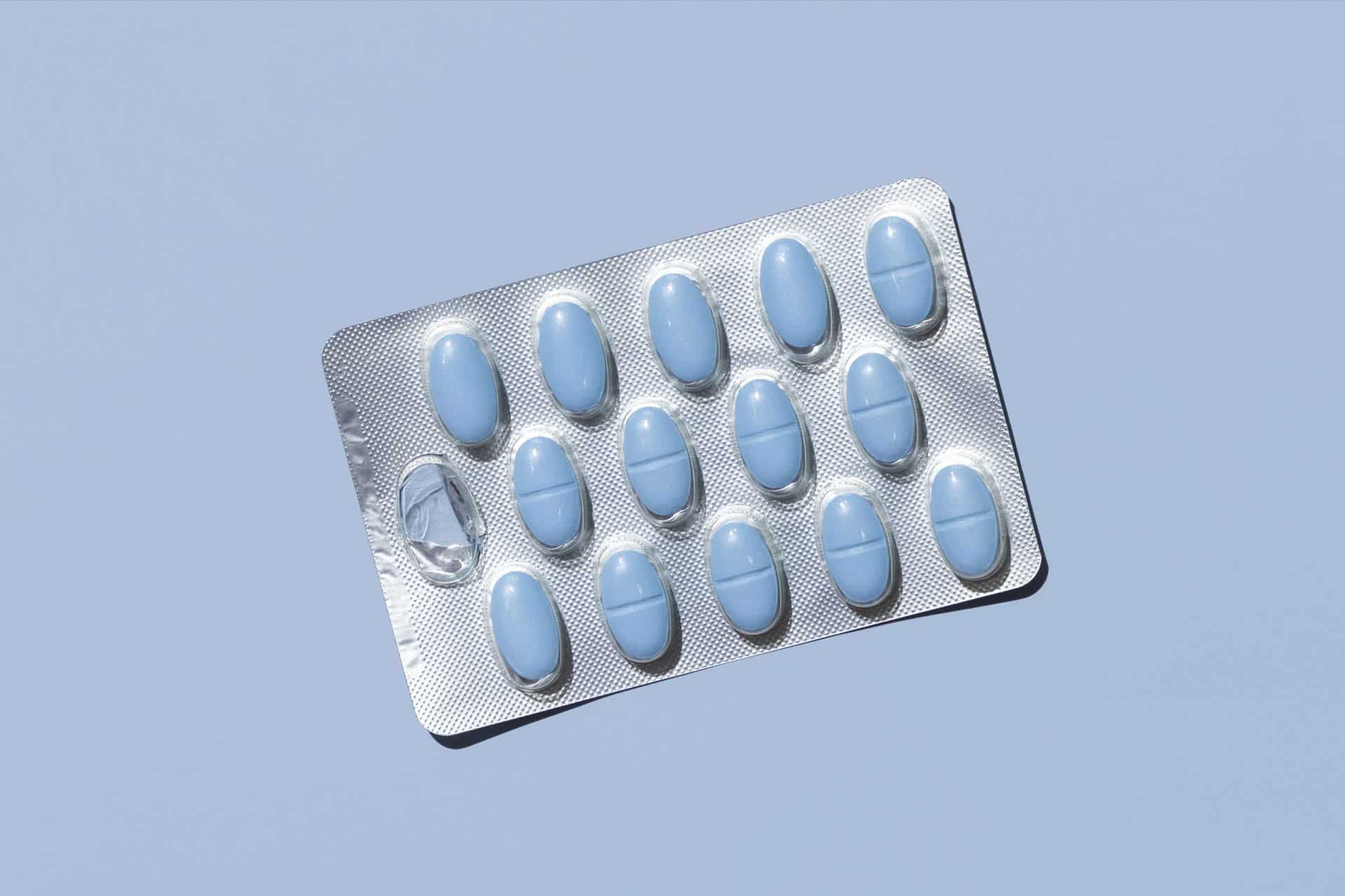 pale blue pills in a blister pack on a pale blue background