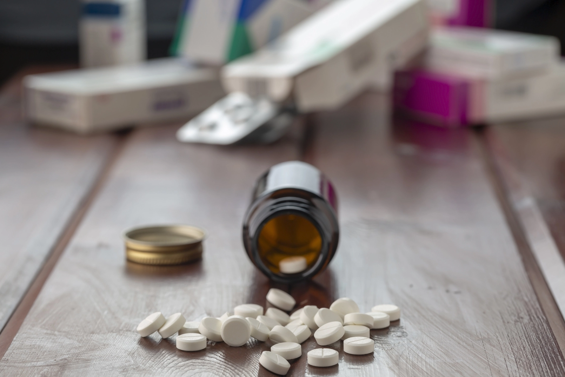 Bottle of Ativan spilling out onto a table with other medications in the background