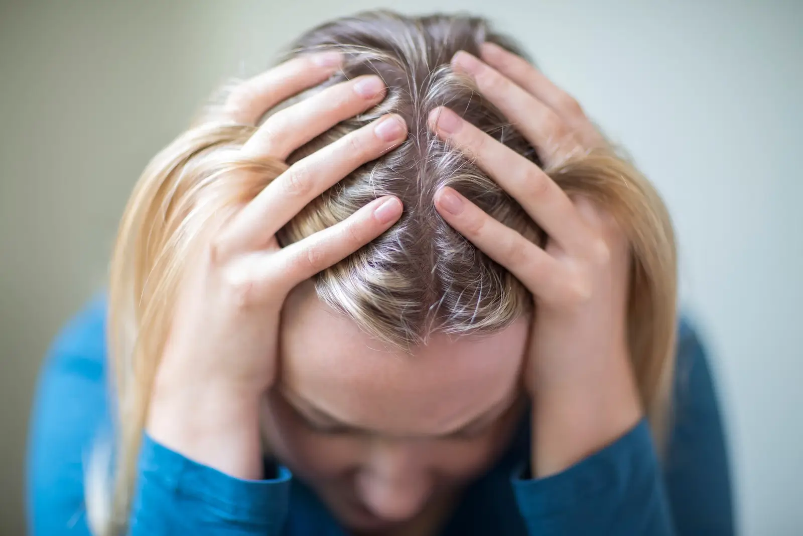 Depressed person holding her head.