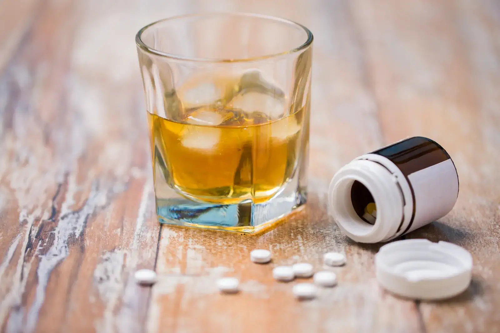 Cymbalta and alcohol. Glass of alcohol and pills on table